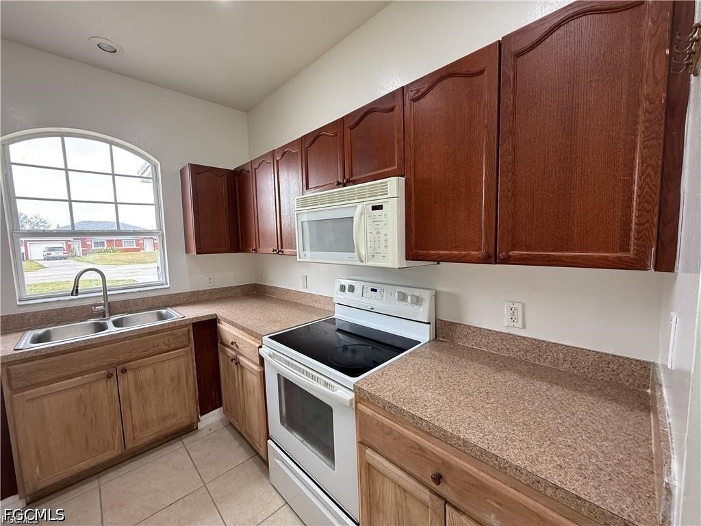 3967 Sunset Road Lehigh Acres, FL 33971 - Photo 7 of 10 a kitchen with a sink stove and microwave