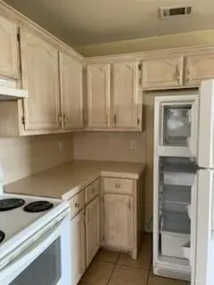 a kitchen with white cabinets and white appliances