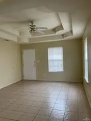 an empty room with a ceiling fan and window