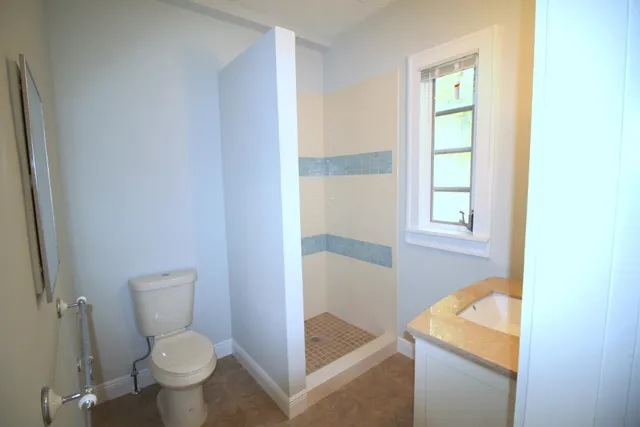 a bathroom with a sink toilet and window