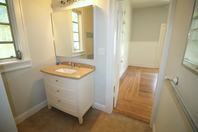 a bathroom with a granite countertop sink and a mirror