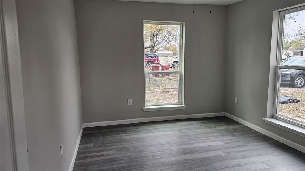 1624 Cedar Street Bonham, TX 75418 - Photo 2 of 8 an empty room with wooden floor and windows