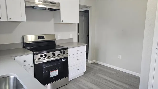 a kitchen with stainless steel appliances white cabinets and a stove
