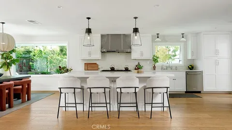 a kitchen with stainless steel appliances granite countertop a table and chairs in it