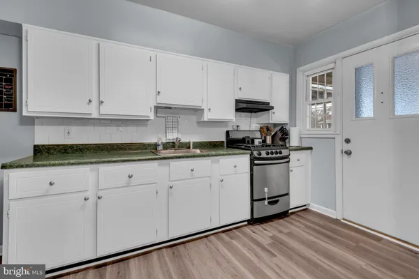 a kitchen with stainless steel appliances granite countertop a refrigerator sink and white cabinets