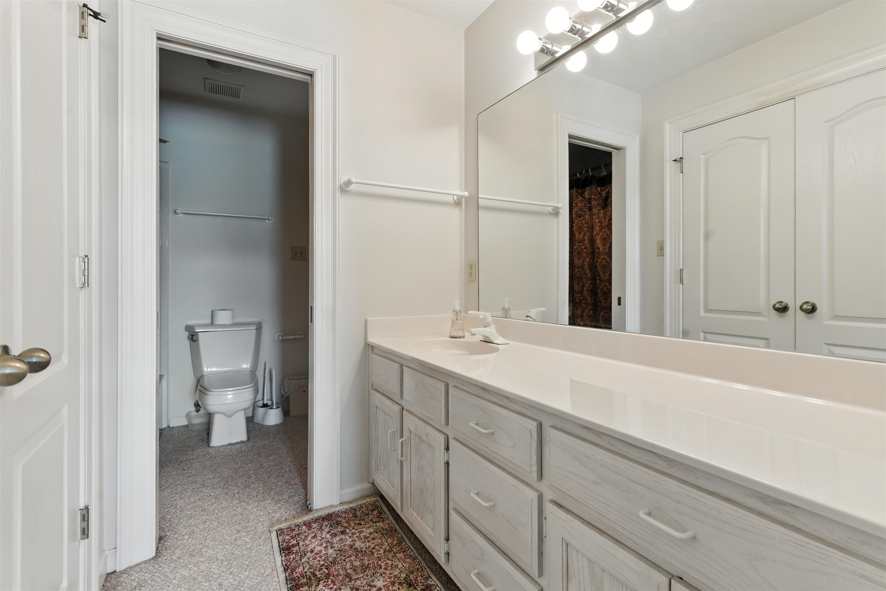 1452 Solo Road Covington, TN 38019 - Photo 28 of 39 a bathroom with a sink a toilet and a large mirror