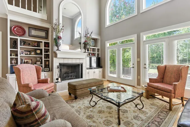 a living room with furniture fireplace and a large window
