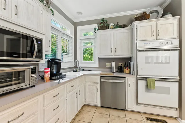 a kitchen with white cabinets and appliances
