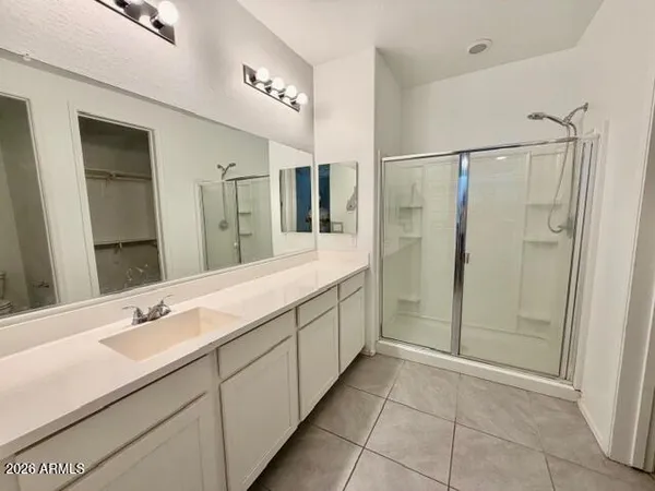 a spacious bathroom with a shower sink and mirror