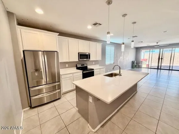a kitchen with stainless steel appliances a refrigerator sink and microwave