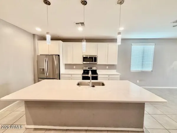 a large kitchen with stainless steel appliances a refrigerator sink and cabinets