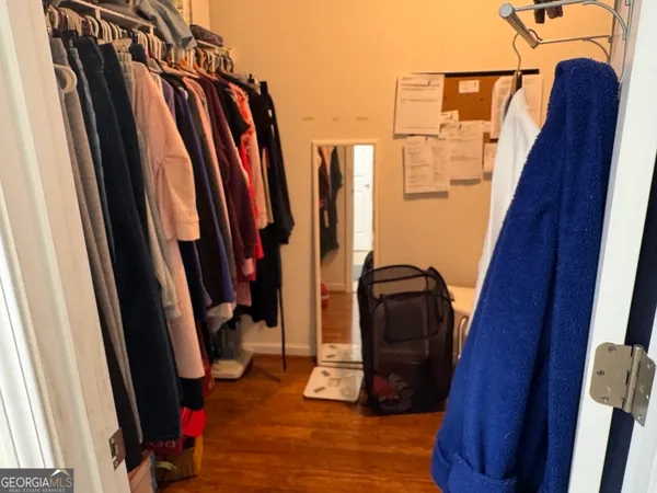 a view of walk in closet with clothes and shoes