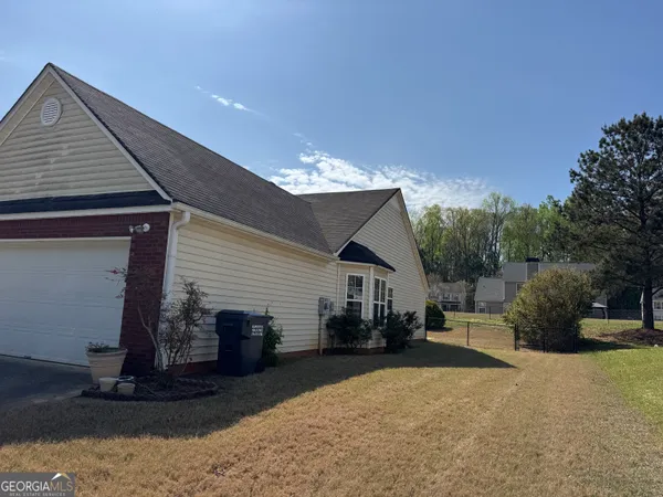 a view of a house with backyard and sitting area
