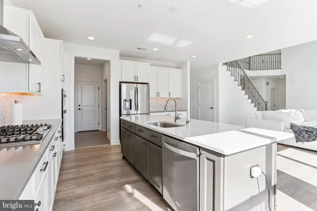 a kitchen with stainless steel appliances granite countertop a sink stove and wooden floor