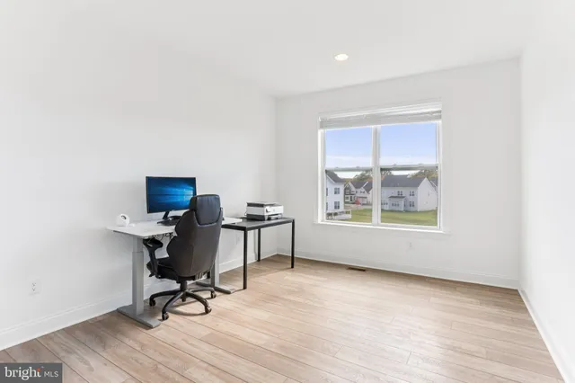 a view of a workspace with furniture and a window