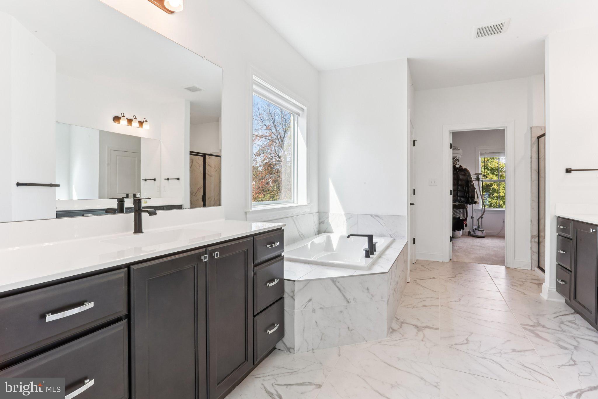 222 Grv Vly Court Chalfont, PA 18914 - Photo 24 of 46 a spacious bathroom with a double vanity sink a large mirror and a bathtub
