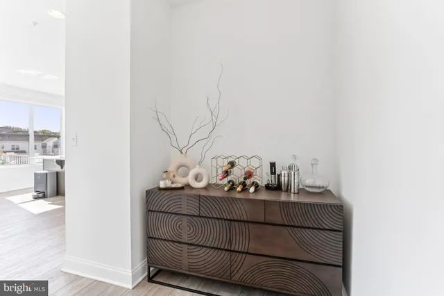 a kitchen with stainless steel appliances kitchen island granite countertop a refrigerator a stove a sink and white cabinets with wooden floor