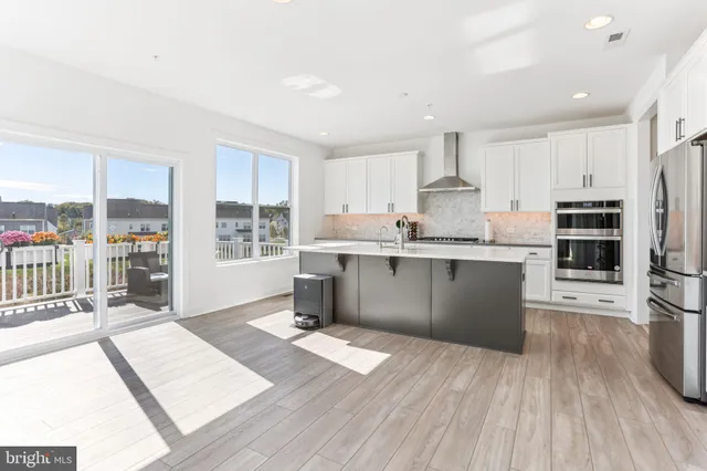 a kitchen with kitchen island granite countertop a sink cabinets and stainless steel appliances