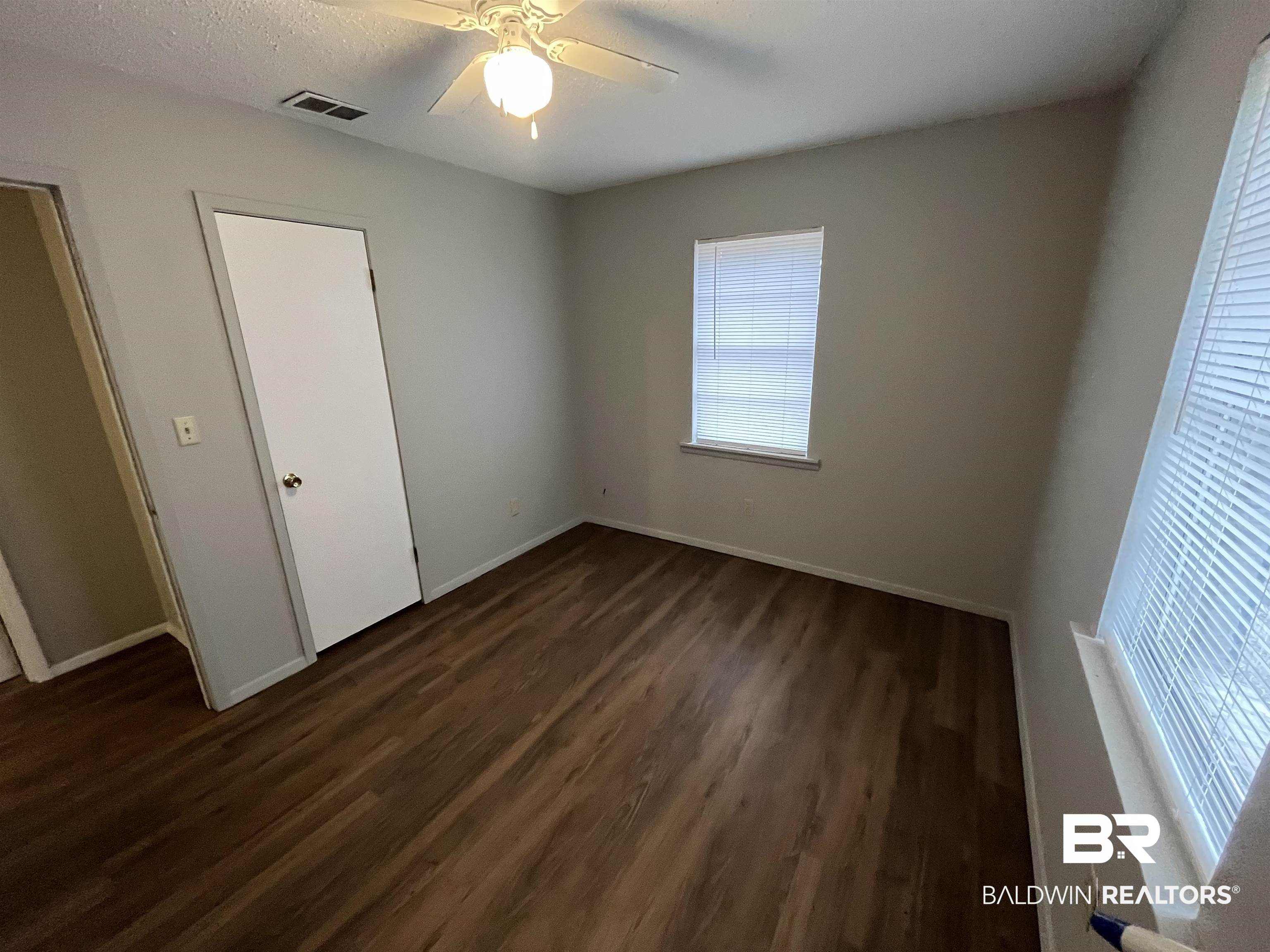 103 Roadway Street Brewton, AL 36426 - Photo 12 of 13 Unfurnished bedroom featuring a textured ceiling, dark hardwood / wood-style floors, and ceiling fan