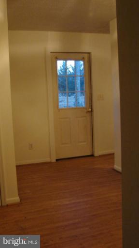 91 Ball Run Road Great Cacapon, WV 25422 - Photo 18 of 26 a view of an empty room with wooden floor and a window