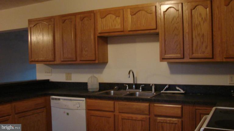 91 Ball Run Road Great Cacapon, WV 25422 - Photo 7 of 26 a kitchen with granite countertop stainless steel appliances wooden cabinets and a sink