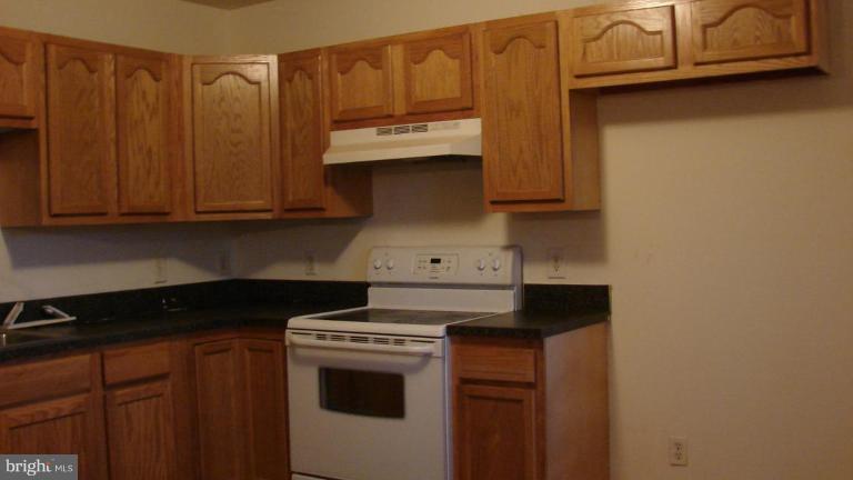 91 Ball Run Road Great Cacapon, WV 25422 - Photo 9 of 26 a kitchen with granite countertop cabinets and stove