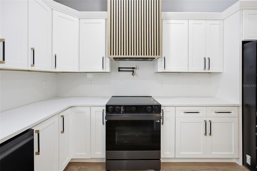 13186 Southwest 52nd Lane Road Ocala, FL 34481 - Photo 14 of 37 a kitchen with white cabinets and a stove