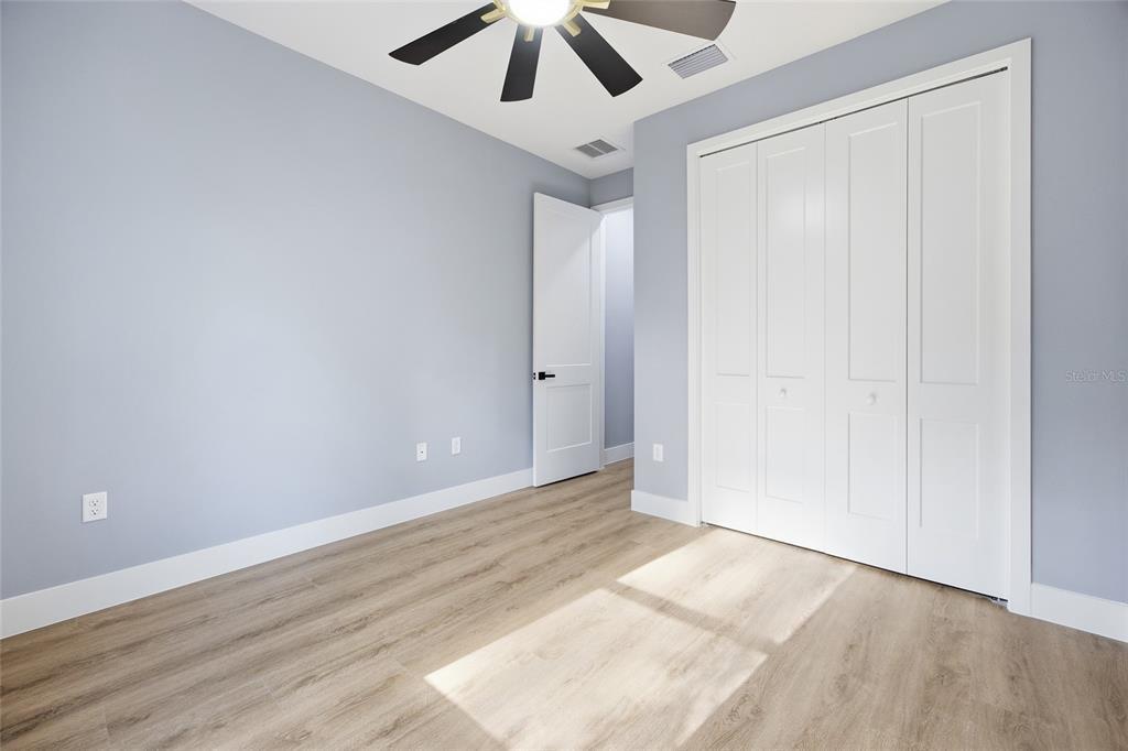 13186 Southwest 52nd Lane Road Ocala, FL 34481 - Photo 21 of 37 an empty room with wooden floor chandelier fan and closet area