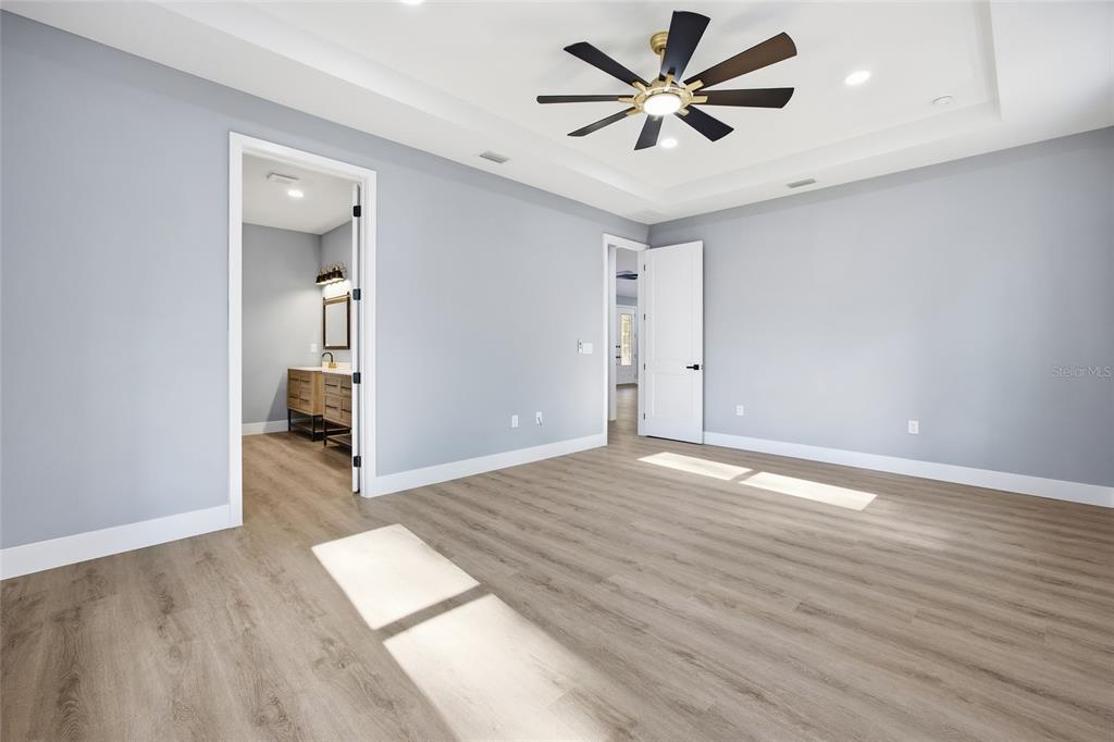 13186 Southwest 52nd Lane Road Ocala, FL 34481 - Photo 23 of 37 an empty room with wooden floor and a ceiling fan