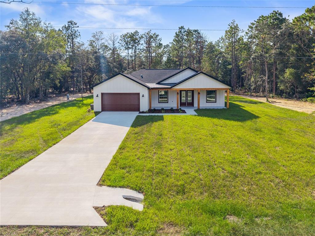 13186 Southwest 52nd Lane Road Ocala, FL 34481 - Photo 3 of 37 a front view of a house with yard and green space