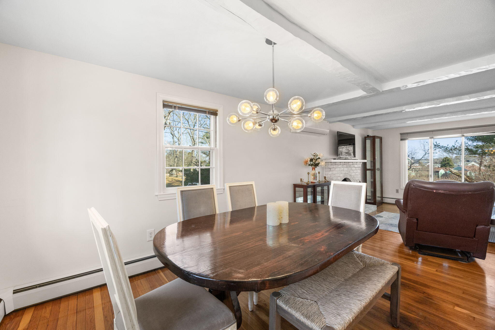 105 Annable Point Road Centerville, MA 02632 - Photo 7 of 27 a dining room with wooden floor a chandelier a glass table and chairs