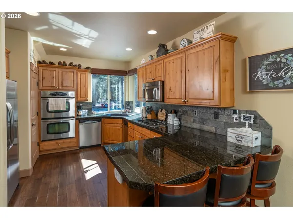 a kitchen with kitchen island granite countertop a sink cabinets and stainless steel appliances