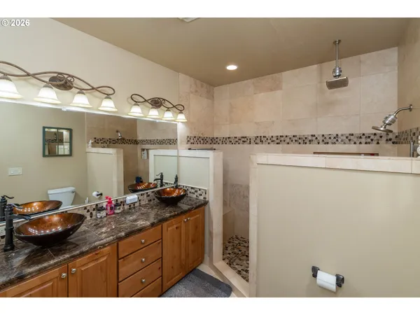 a bathroom with a granite countertop sink a mirror and a shower