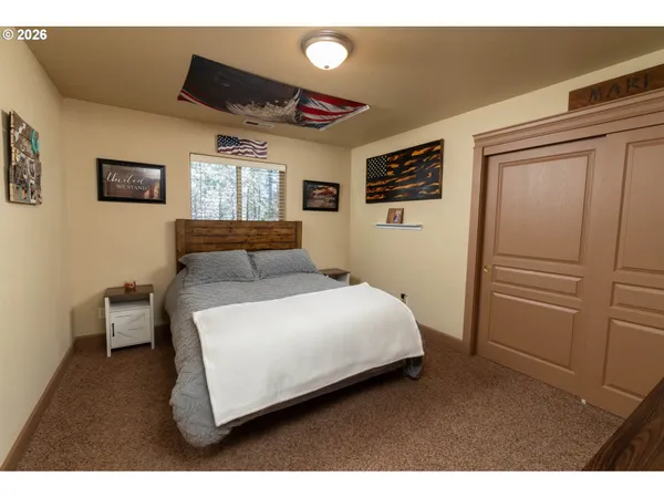 a bedroom with a bed and a refrigerator