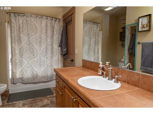 a bathroom with a sink vanity mirror and tub