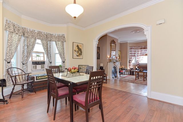 a view of a a dining room with furniture window and wooden floor