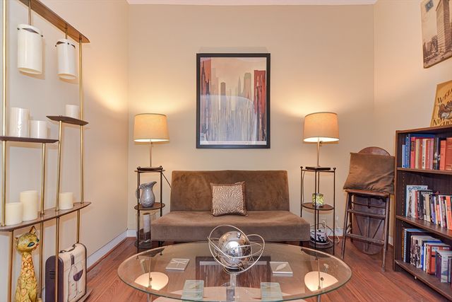 a living room with furniture a bookshelf and a wooden floor