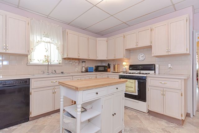 a kitchen with cabinets appliances a sink and a window
