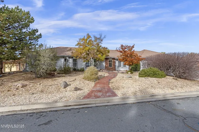 front view of a house with a yard and mountain view in back
