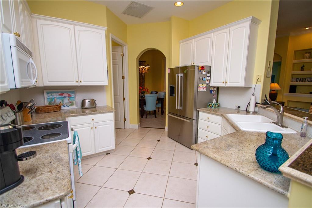 8229 Allendale Court Naples, FL 34120 - Photo 30 of 50 a kitchen with stainless steel appliances granite countertop a refrigerator and a sink
