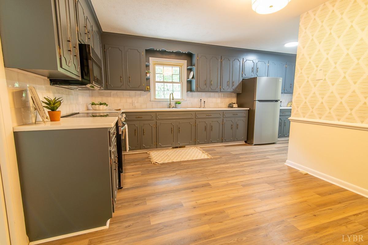 219 Izaak Walton Road Amherst, VA 24521 - Photo 12 of 32 a kitchen with stainless steel appliances granite countertop a refrigerator a sink dishwasher a stove with wooden cabinets and floor