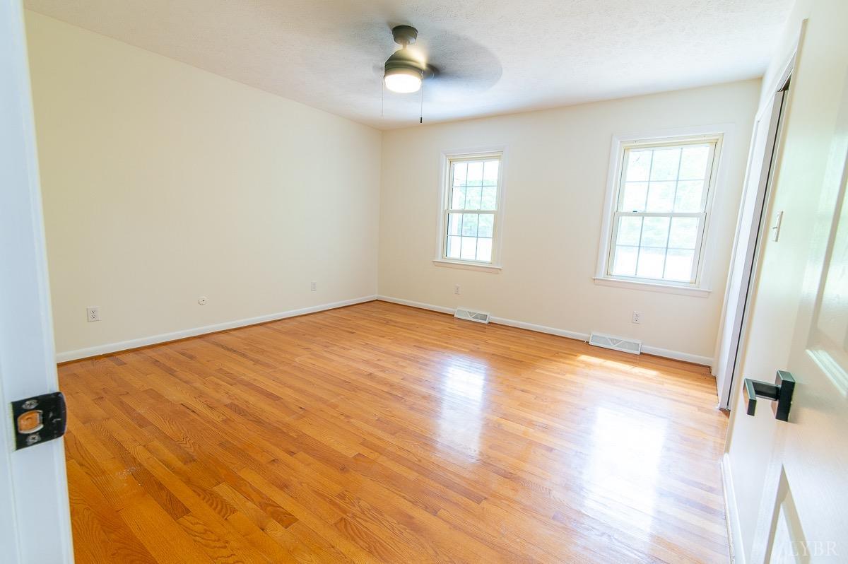 219 Izaak Walton Road Amherst, VA 24521 - Photo 21 of 32 a view of empty room with wooden floor and fan