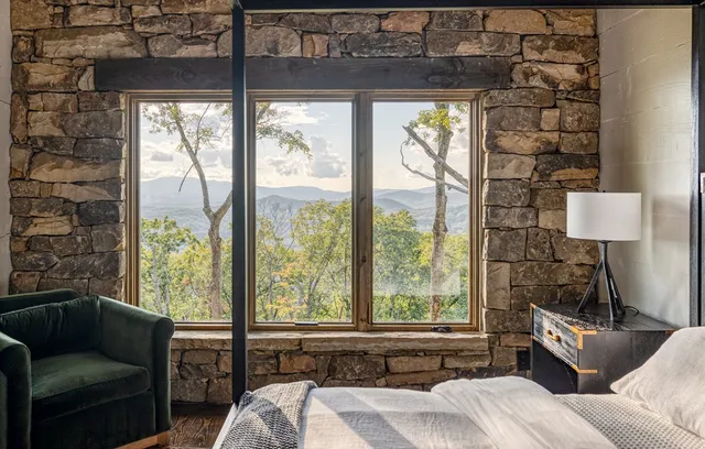 a bedroom with furniture and a large window
