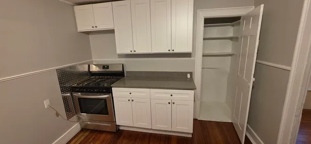 a kitchen with granite countertop white cabinets and white appliances