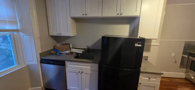 a kitchen with a refrigerator and cabinets