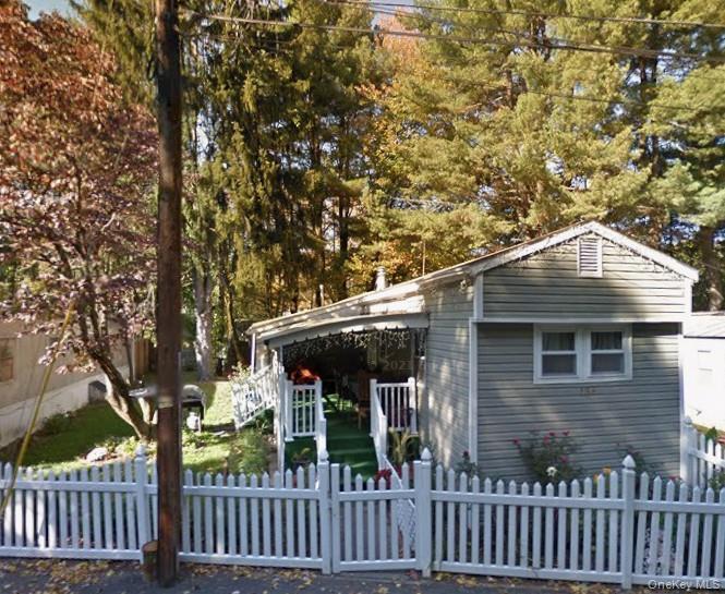 136 Quaker Rd Park Pomona, NY 10970 - Photo 1 of 24 Single-story residence featuring light gray siding and a white picket fence