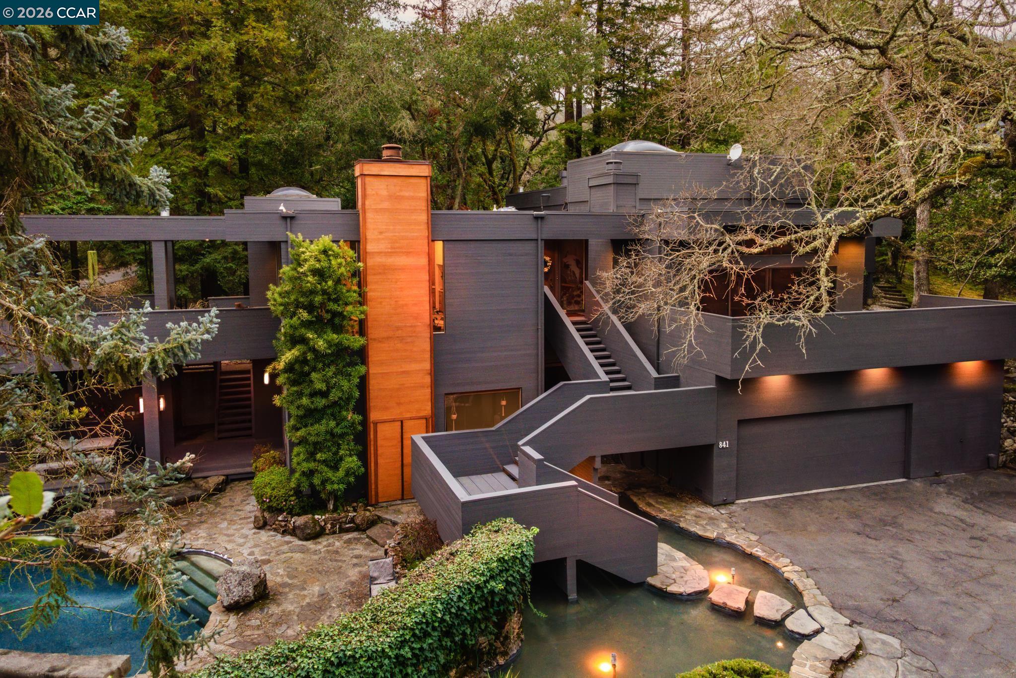 an aerial view of a house with a yard and large trees