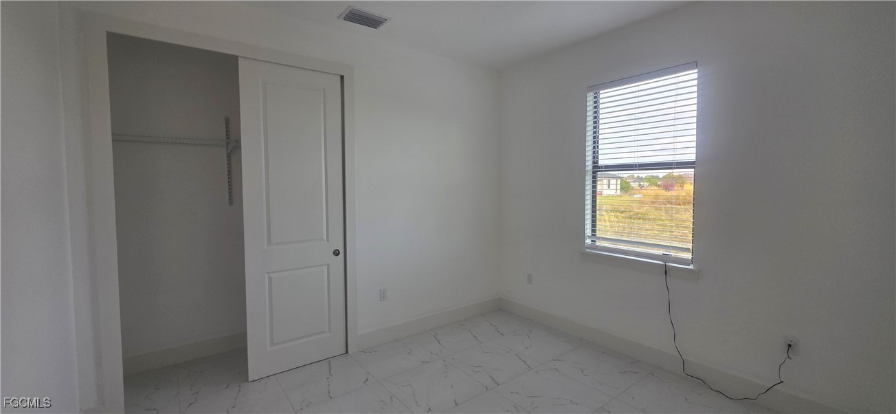 927 Chenault Street Lehigh Acres, FL 33974 - Photo 13 of 16 an empty room with windows
