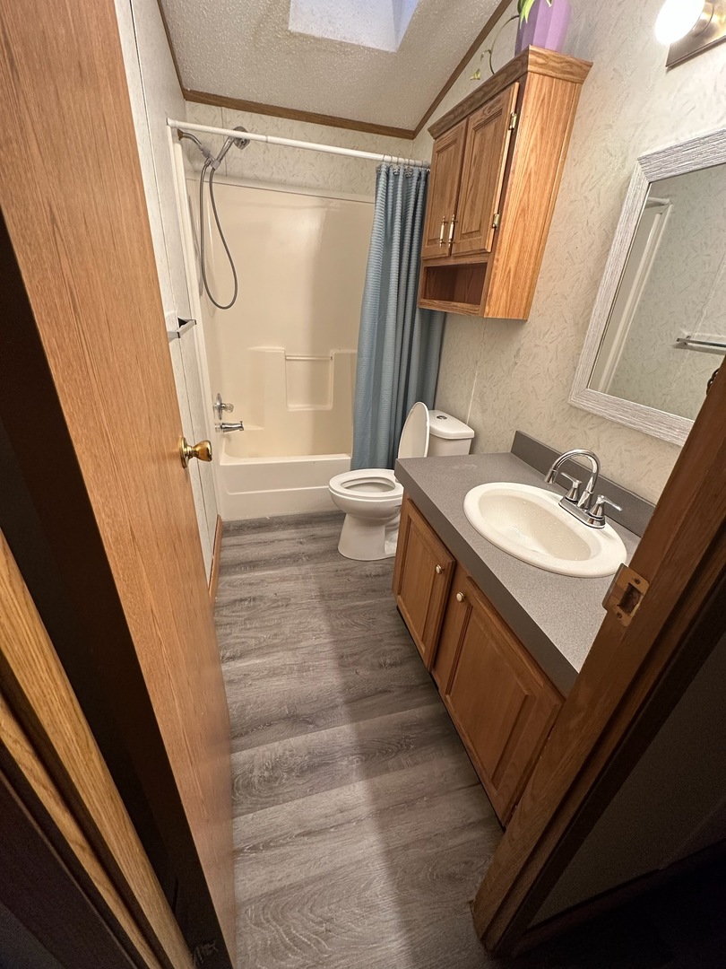 8800 South Harlem Avenue, Unit 809 Bridgeview, IL 60455 - Photo 11 of 14 a bathroom with a sink a toilet a mirror and shower