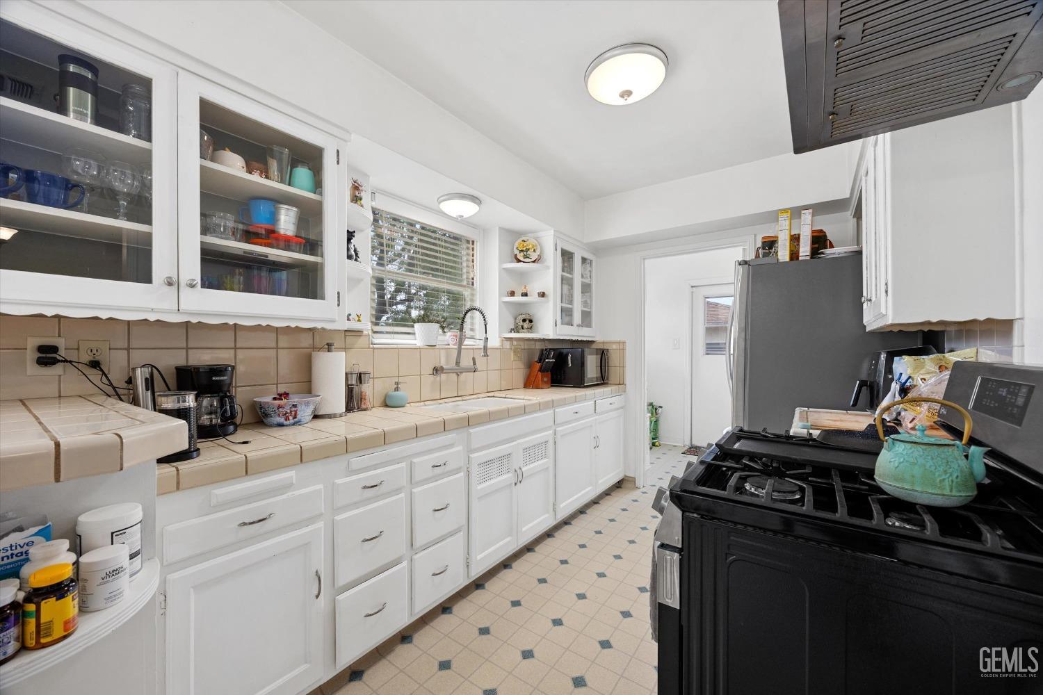 Undisclosed Address Bakersfield, CA 93305 - Photo 24 of 46 a kitchen with stainless steel appliances kitchen island granite countertop a refrigerator and a stove